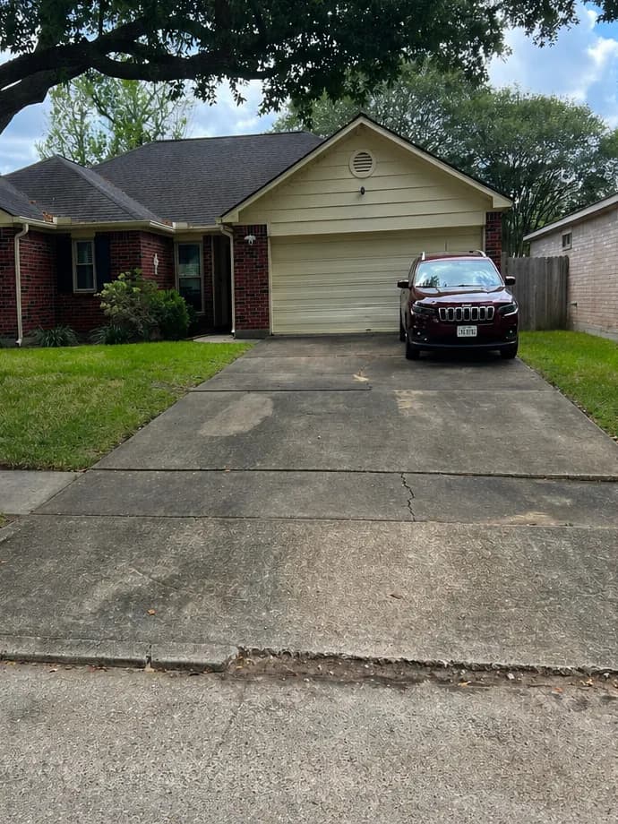 Concrete driveway darkened by dirt and mildew before pressure washing